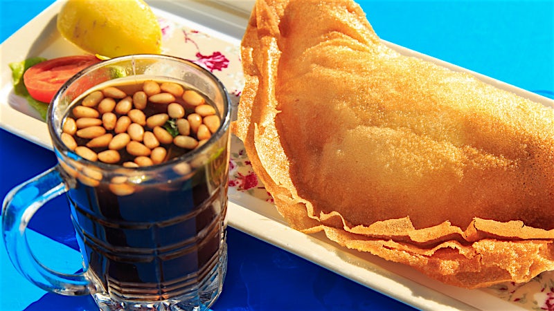 Traditional Tunisian brik pastry served with olives and mint tea.