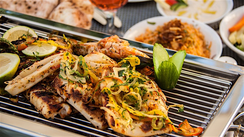 Grilled seafood platter with prawns, fish and Mediterranean side dishes in Egypt.
