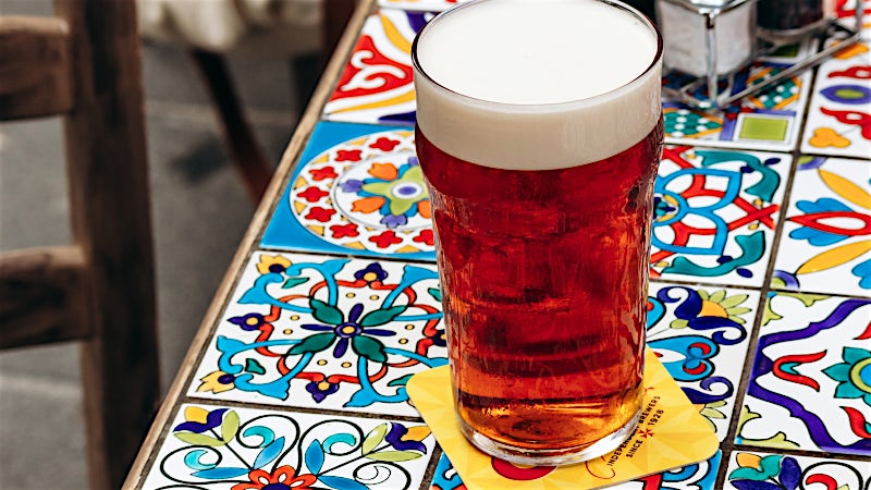 raditional Maltese beer served on a colourful tiled table in a local pub.