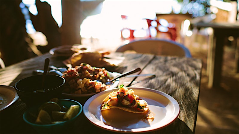 Authentic Mexican taco appetiser served outdoors with fresh salsa and local ingredients.