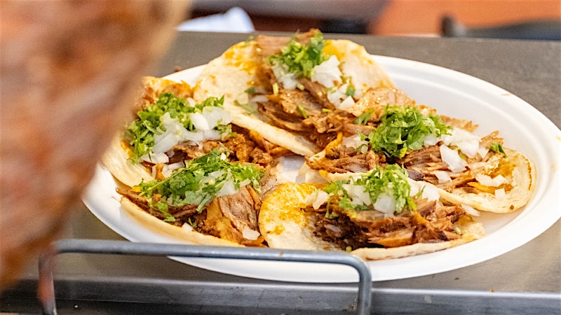 Traditional Mexican street tacos topped with slow-cooked meat, onion and coriander.