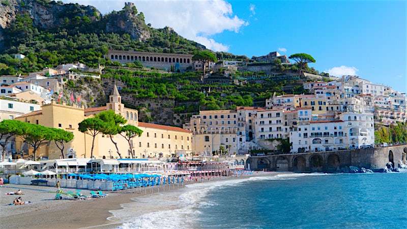 Amalfi beachfront town with cliffside buildings, historic architecture and Mediterranean coastline, Italy.