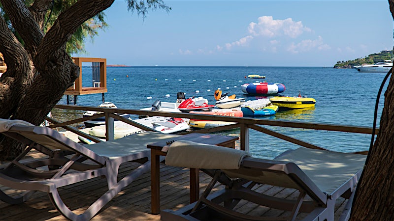 Seafront resort deck with sun loungers, water sports and Mediterranean coastline in Turkey