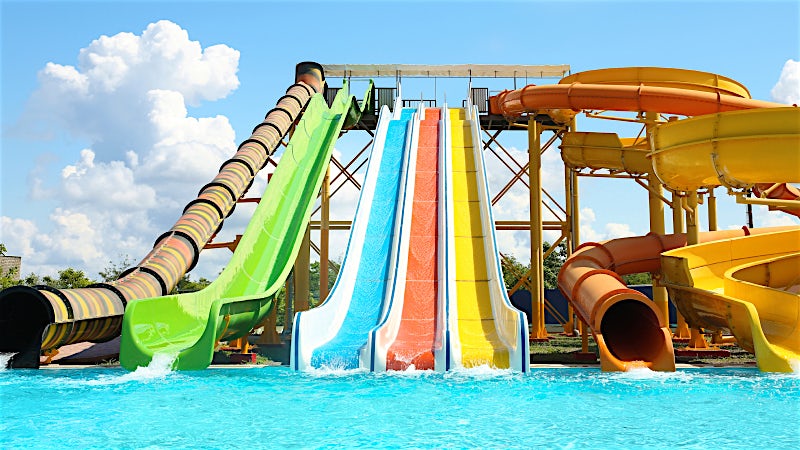 Colourful water slides and splash pool at a family water park resort.
