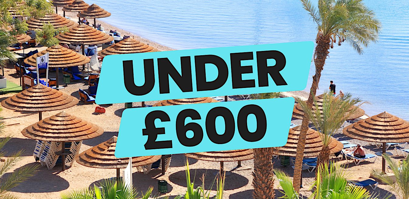 Beach resort lined with thatched sunshades beside a calm shoreline, promoting Value holidays and summer escapes for under £600.