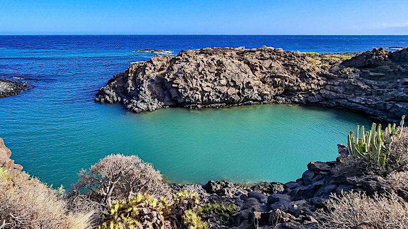 Turquoise waters surround volcanic rock formations at Golf del Sur, offering peaceful coastal views for Tenerife Value holidays.