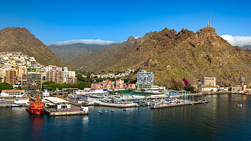 Santa Cruz de Tenerife harbour framed by rugged mountains and waterfront buildings, highlighting city and coast Value holidays.