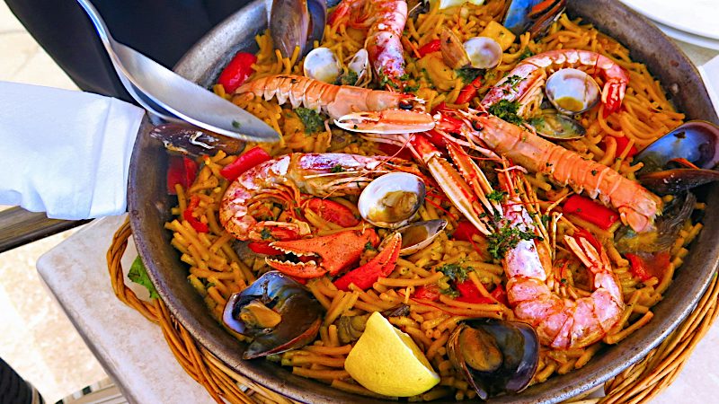 Seafood paella with prawns, mussels, clams and lobster served in a traditional Spanish pan.